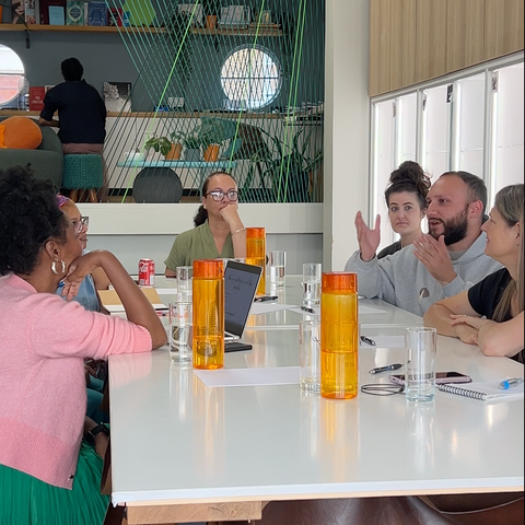 Group of people sitting around a table in a modern learning setting